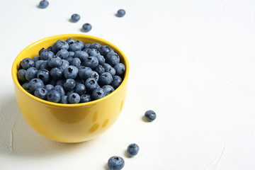 Crockery with juicy and fresh blueberries on white table. Space for text