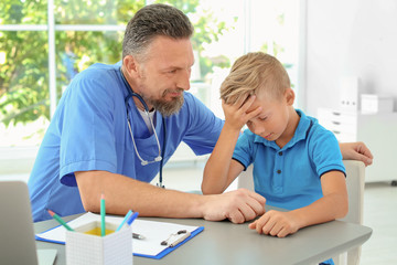 Obraz premium Male medical assistant consulting child in clinic