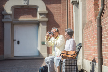 旅先でカメラを構えるシニア夫婦