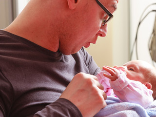 Father holding taking care of newborn baby