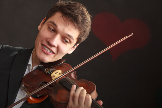 Man man dressed elegantly playing violin