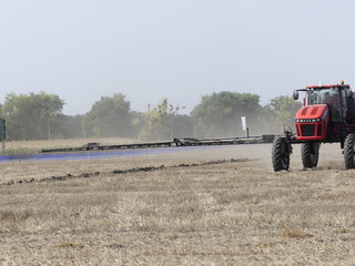 Fototapeta premium Exhibition of agricultural machinery. Agrotechnics works in the field. The tractor lights the field. Irrigation machine.