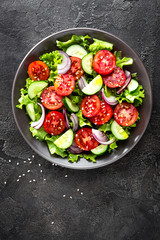 Fototapeta na wymiar Salad. Fresh vegetable salad with tomato, cucumber, lettuce and red onion