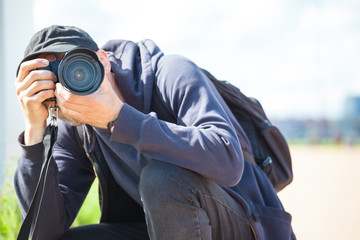 male photographer with a large professional camera looks into the viewfinder and takes pictures