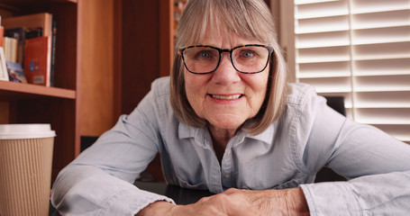 Close up of lovely senior woman video chatting while smiling in home office