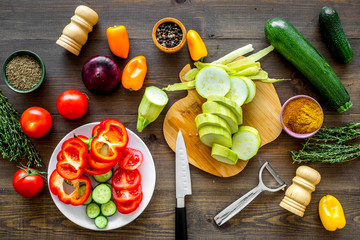 Cut different fresh vegetables on cutting board for cooking vegetable stew. Dark wooden background...