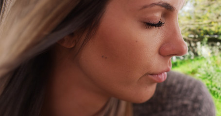 Fototapeta premium Extreme close-up of wind blowing hair of gentle young lady in nature setting