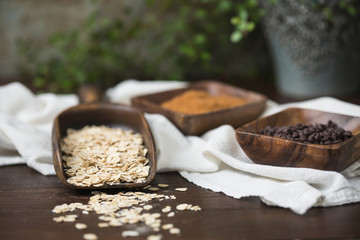 Raw Oatmeal in Wood Scoop; Coconut Brown Sugar and Mini Chocolate Chips in Wood Bowls; Wood Table