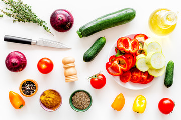 Healthy food concept. Ingredients for vegetable stew. Squash, bell pepper, tomato, spices, oil on white background top view