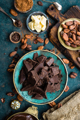 Fototapeta na wymiar Chocolate. Dark bitter chocolate chunks, cacao butter, cocoa powder and cocoa beans. Chocolate background