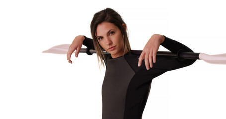Young woman in wetsuit holding kayak paddle over shoulders on white background