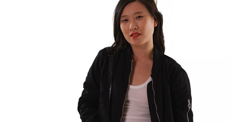 Chinese woman in black bomber jacket looking at camera on white background