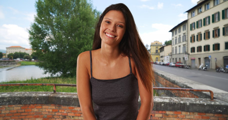 Beautiful Caucasian girl wearing tank top standing on street in Venice Italy