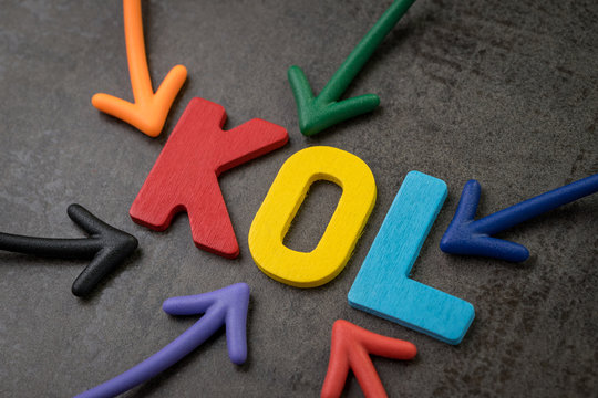 KOL abbreviation of Key Opinion Leader, influencer concept, colorful arrows pointing to the word KOL at the center of black cement wall, new social media marketing in digital world