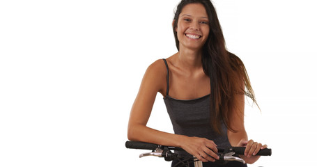 Fototapeta na wymiar Pretty brunette female with her bike on white background smiling at camera