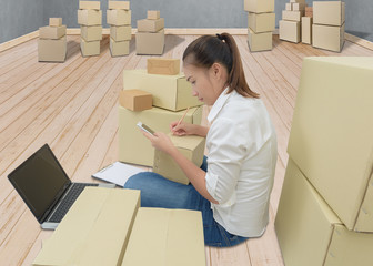 teenager owner business woman work at home with smartphone, laptop for online shopping writing the order.