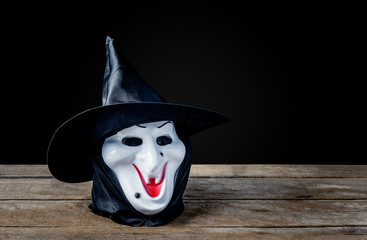 Halloween Witch mask on wooden floor and black background
