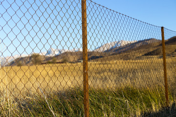 metal fence in the field at sunset