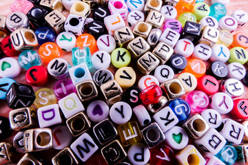 Colorful plastic alphabet dice on a wooden background as a background.
