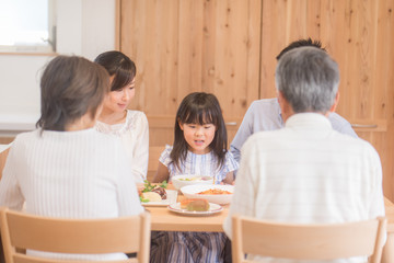 自宅で食事を楽しむ三世代家族