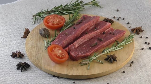 Sliced beef on cutting board with Rosemary