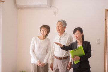 住宅を内見するシニア夫婦と不動産会社のビジネスウーマン