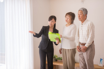 住宅を内見するシニア夫婦と不動産会社のビジネスウーマン