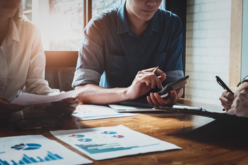 Businessman using calculator  are meeting to plan sales to meet targets set in next year. audit...
