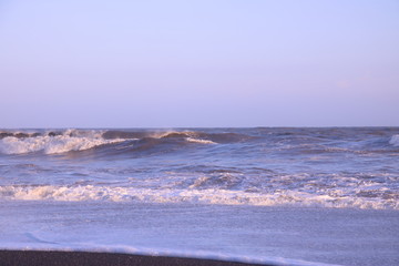 夕暮れ時の日本海の荒波と砂浜