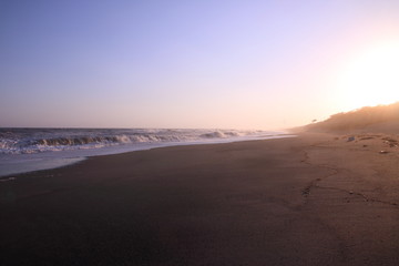 Fototapeta na wymiar 夕暮れ時の日本海の荒波と砂浜