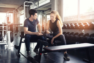 Muscular young woman with beautiful  body doing exercises with dumbbell. Sporty girl lifting weights in gym.