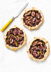 Caramelized figs tarts or pies on a light background, top view. Flat lay