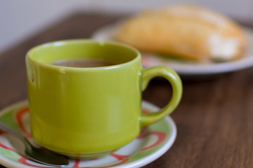 coffee with milk and bread with butter on the table - simple and practical breakfast