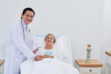 Obraz premium Cheerful mature doctor supporting senior female patient after surgery