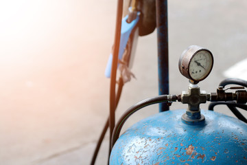 old blue air compressor pump with old gauge bar