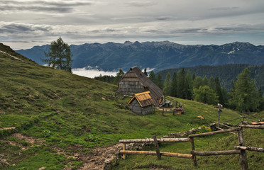 Obraz premium Traditional wooden shepherd huts on high alpine meadow in slovenian part of Julian Alps