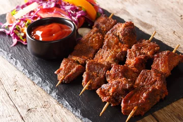 Poster Recipe of a spicy African suya kebab on skewers with fresh vegetable salad and ketchup close-up. horizontal © FomaA