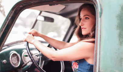 Fototapeta na wymiar a woman driving an old classic pickup truck