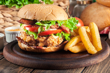 Delicious burger with chicken, bacon, tomato and cheese
