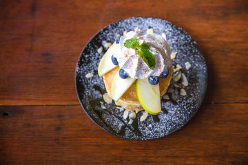 pancakes mixed fruits and maple syrup, apple and blueberry topping on pancakes. sweets with syrup and fruits concept. food decoration. image for background, wallpaper and menu list.