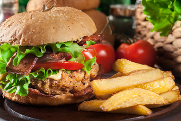 Delicious burger with chicken, bacon, tomato and cheese
