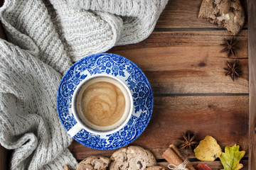 Morning fragrant and wooden background. Biscuit biscuits with chocolate for breakfast and a warm knitted plaid. Autumn decoration. Top view. Copy space.