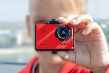 action camera red in the hands of a man, blurred background