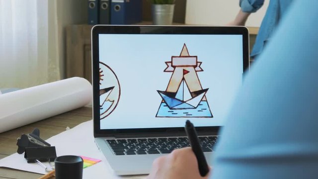 Young designer creating new logo on the laptop computer