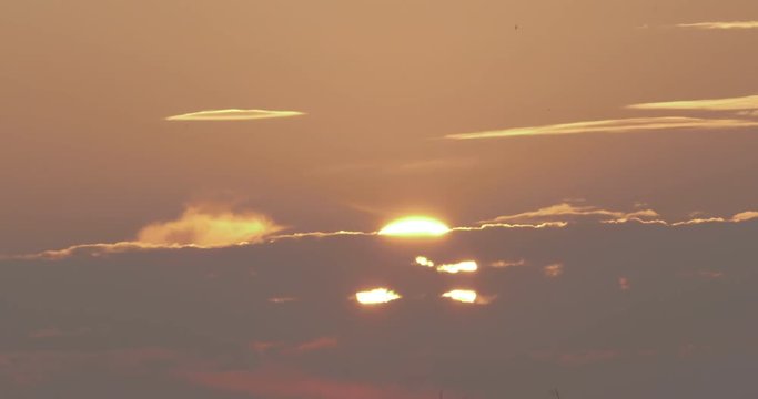 Evening sun hides behind the clouds at golden hour before sunset.