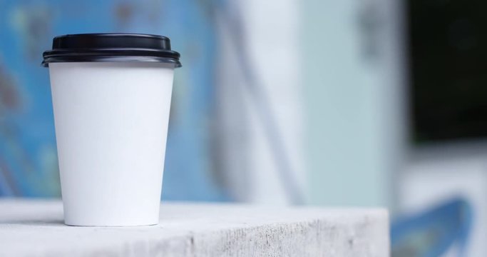 Plain white to go coffee cup on table outdoors - copy space right