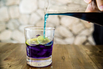 Welcome drink, butterfly pea flower juice with lemon slice. natural base test indicator,science at home concept. amazing colorful drinking. image for background, copy space and menu list.