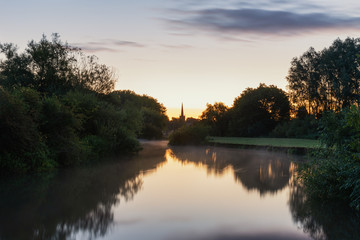 Fototapeta na wymiar Beautiful dawn landscape image of River Thames at Lechlade-on-Thames in English Cotswolds countryside with church spire in background