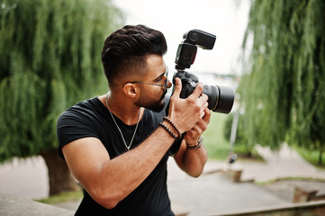 Awesome beautiful tall ararbian beard macho man photographer in glasses and black t-shirt with...