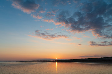 Beautiful vibrant Summer sunset beach landscape with stunning sky and colors
